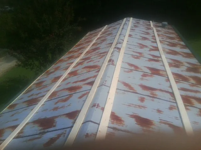 Rusted metal roof panels with new wood purlins before replacement — Storm Damage Roof Repair in Hollansburg by Roofing Brothers