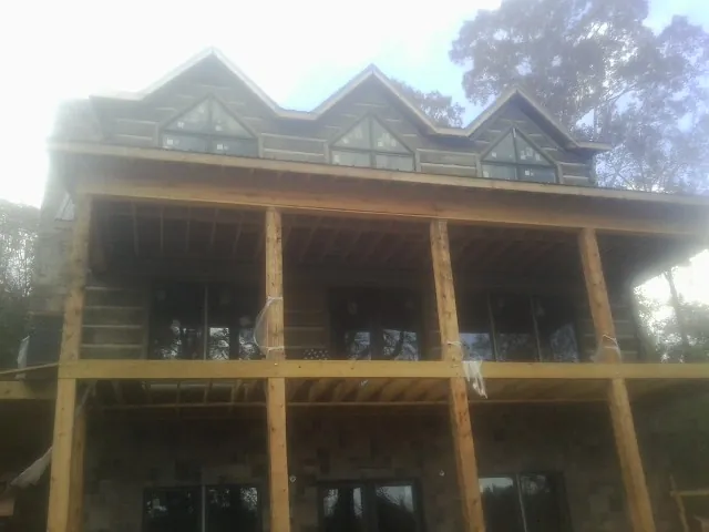 Dormers and porch framing on a large log home under construction — Roof Coating work by our crew in Hollansburg